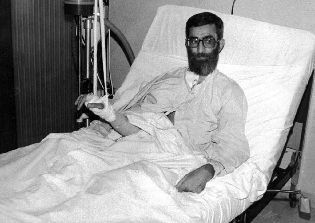 Ayatollah Ali Khamenei in a hospital bed with a bandaged right arm, recovering from a 1981 opposition group bombing in Tehran.