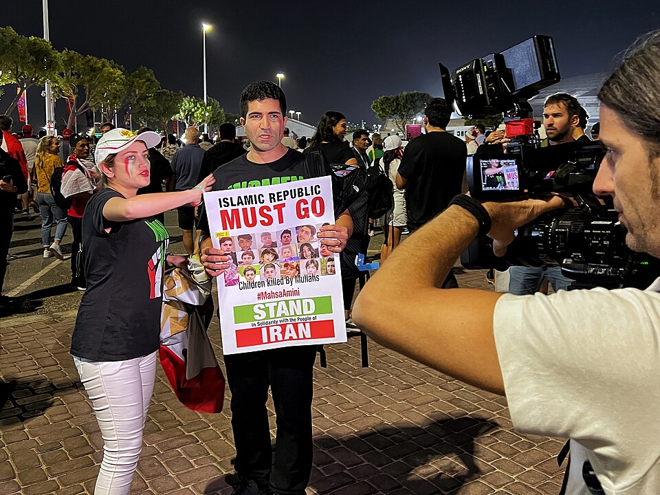 A boy holds a placard reading “Islamic Republic must go” during the 2022 Mahsa Amini protests against Ayatollah Ali Khamenei’s regime.